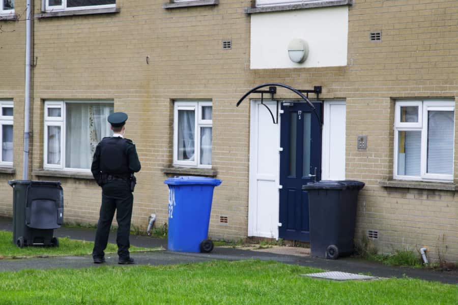 A police officer outside a block of flats in Burrendale Park Road in Newcastle where the body of a 29-year-old man was discovered on Saturday afternoon. Pic: Pacemaker Press