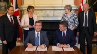 DUP MP Sir Jeffrey Donaldson and Tory Chief Whip Gavin Williamson signed the deal in front of their party leaders